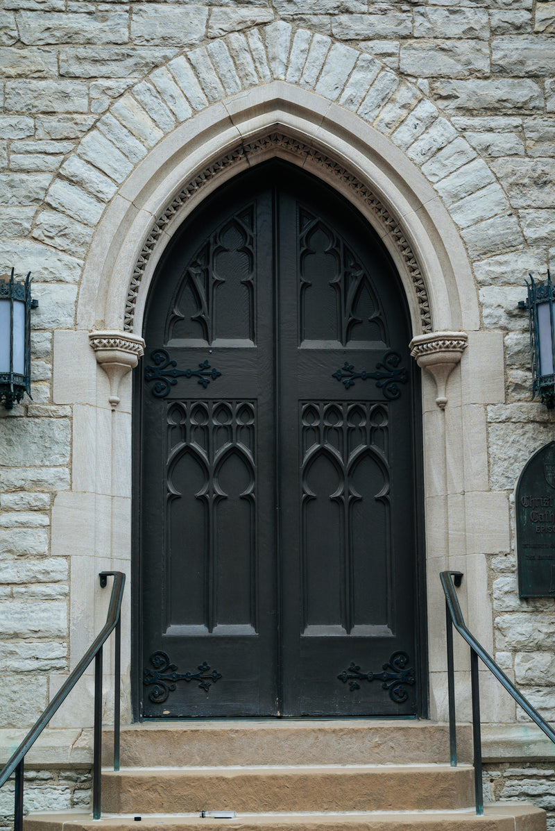Arched wrought iron entry door adding elegance to luxury home exterior
