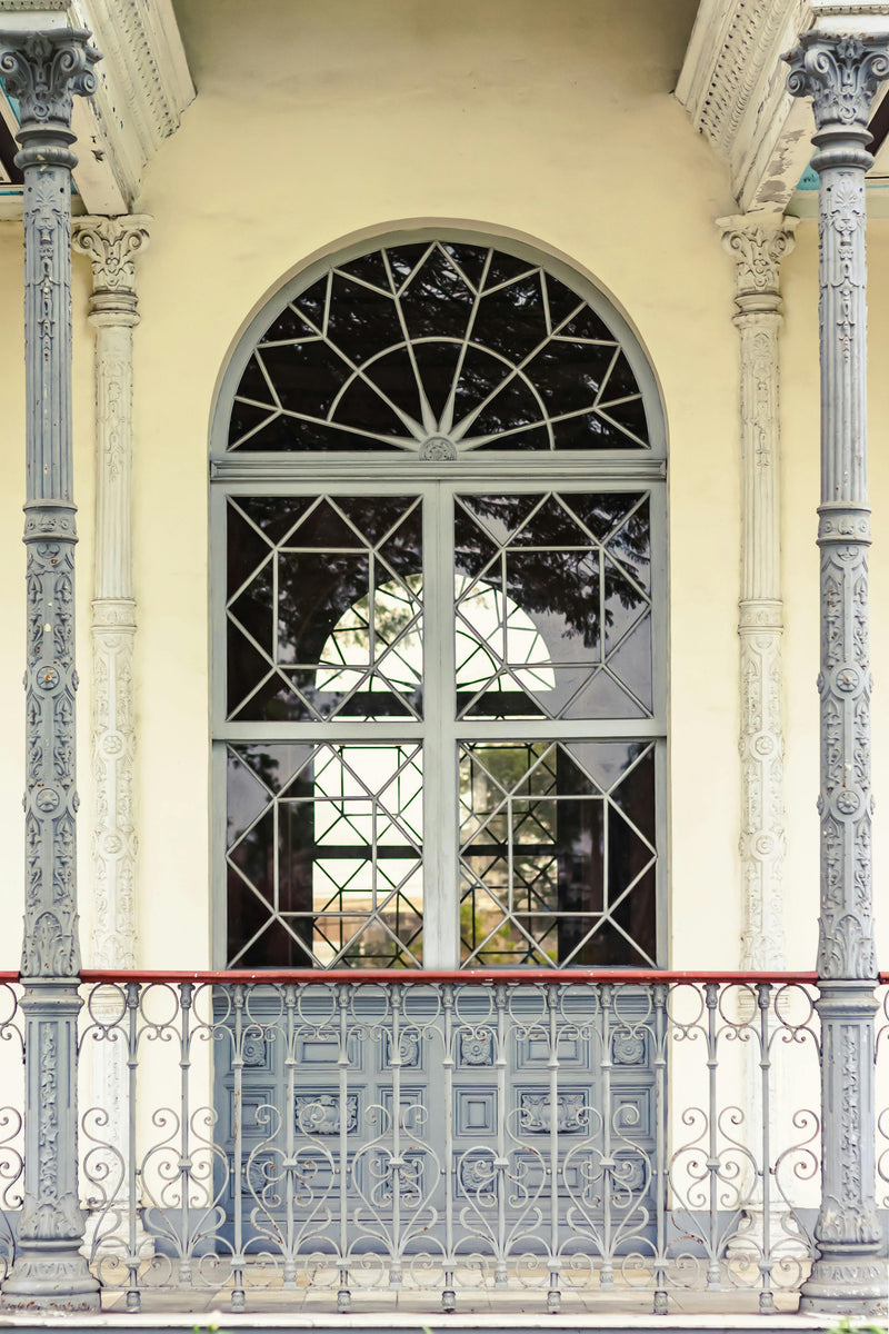 Iron entry door with arched transom window above